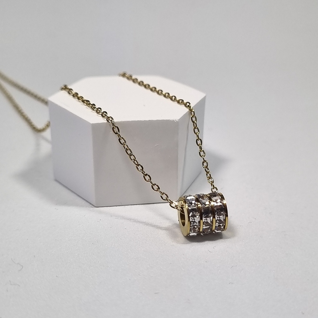 Colgante cilindro dorado con circonitas